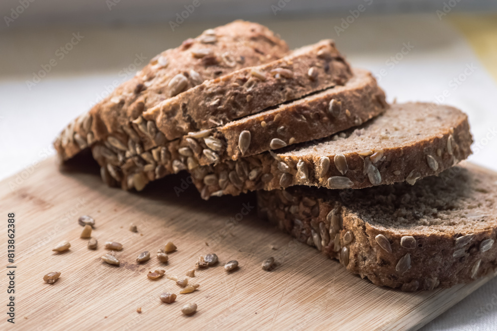 Sliced rye bread with sunflower seeds on wooden cutting board