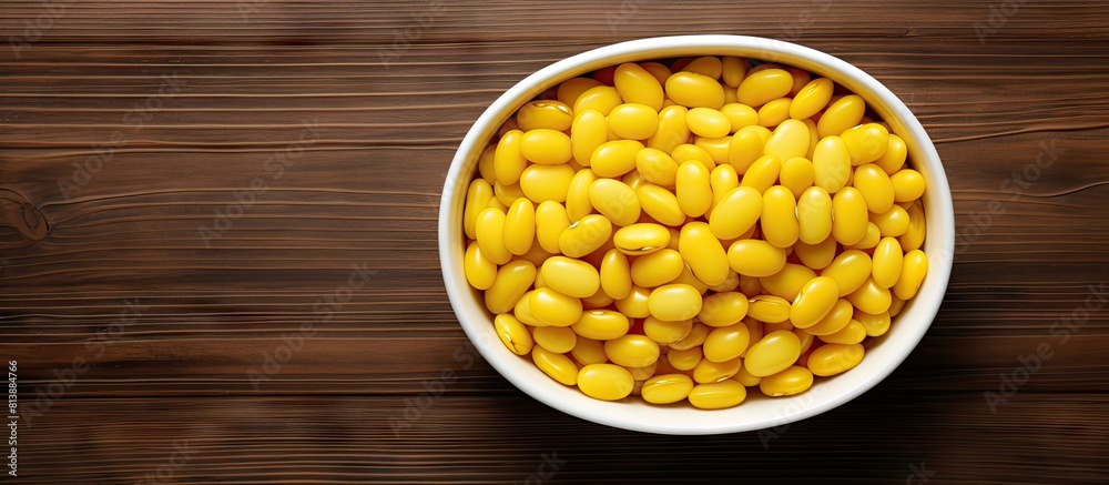 A top view copy space image of yellow kidney beans arranged in a bowl on a wooden table A top view copy space image of yellow kidney beans arranged in a bowl on a wooden table