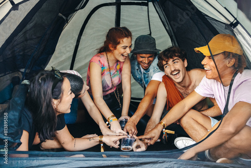 Group of festival goers having fun during a drinking game in a tent photo