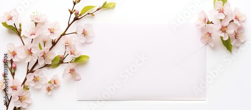 A spring themed postcard mockup featuring flowering branches against a white background with an envelope and white blank space for text. Copy space image. Place for adding text and design
