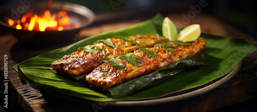 Otak otak a delectable dish consists of minced mackerel delicately encased in banana leaves and cooked over a grill It is typically enjoyed with either peanut sauce or tangy spicy sauce photo