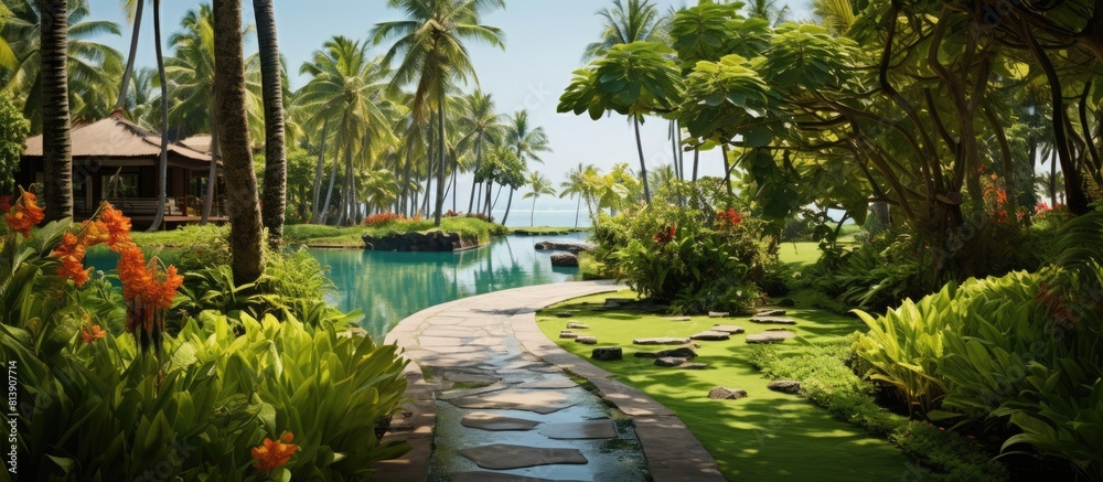 A stunning tropical garden in Asia filled with an array of trees including palms coconut trees and vibrant flowers The pathway leads to a swimming pool and beach beautifully adorned with bamboo walls