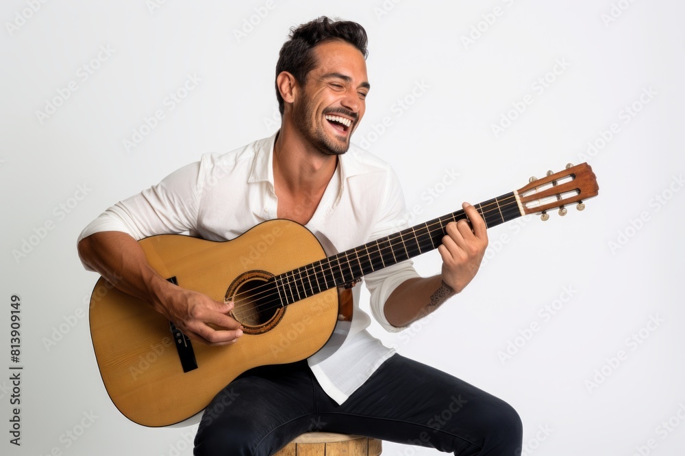 Portrait of a smiling man in his 30s playing the guitar over white background