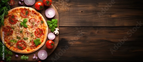 A high angle shot of a delicious homemade Italian pizza resting on a wooden board accompanied by fresh vegetables The image has a blank space. Copy space image. Place for adding text and design photo