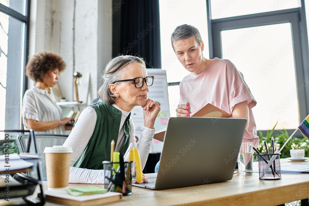 Concentrated diverse female professionals working together on their project in office. Concentrated diverse female professionals working together on their project in office.