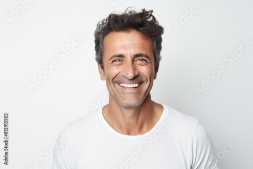 Portrait of a joyful man in his 40s smiling at the camera in front of white background