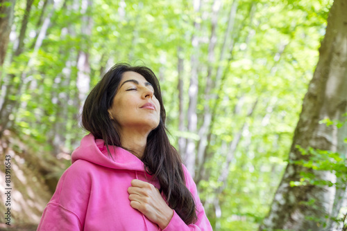 Relaxed woman breathing fresh air in a green spring  forest