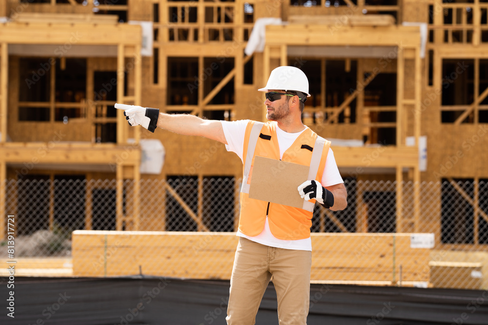 Man Contractor holds piece of empty cardboard sign in his hands. a male construction worker in a helmet stands in a construction zone with empty cardboard. Construction Worker on Duty Man Contractor holds piece of empty cardboard sign in his hands. a male construction worker in a helmet stands in a construction zone with empty cardboard. Construction Worker on Duty