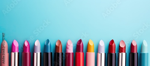 Top view of various stunning lipsticks on a light blue backdrop perfect for adding text. Copy space image. Place for adding text and design