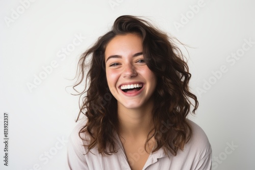 Portrait of a happy woman in her 20s smiling at the camera on white background
