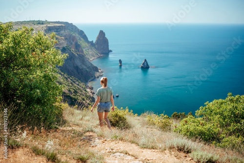 A woman is walking on a beach near the ocean