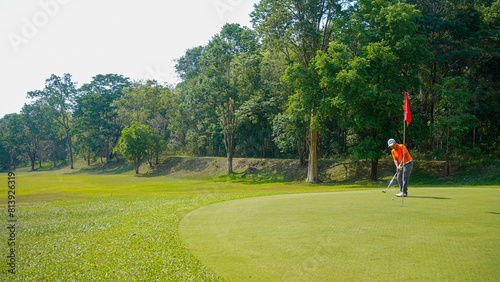 Golfer are playing game golf and hitting go on green grass mountain background.