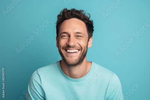 Obraz na płótnie Portrait of a blissful man in his 30s smiling at the camera while standing against pastel blue background w salonie