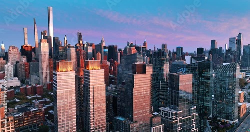 Skyscrapers with pink light on the facades at sunset. Drone footage among the beautiful buildings in New York downtown.