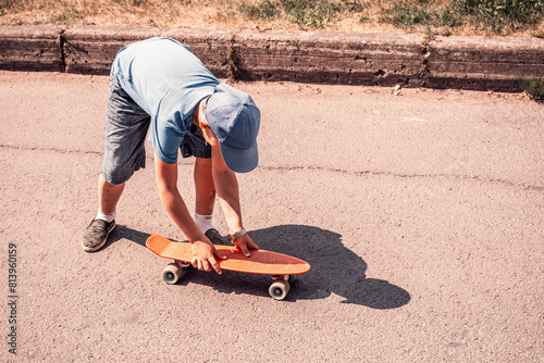 a boy rides a skateboard on an asphalt road on a sunny day