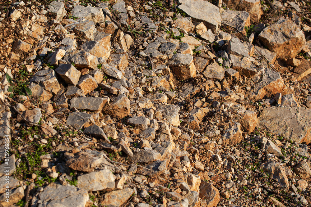 Red rocks of different shapes and sizes on the ground. Orange texture. Background. For text. For banner. Horizontal Red rocks of different shapes and sizes on the ground. Orange texture. Background. For text. For banner. Horizontal