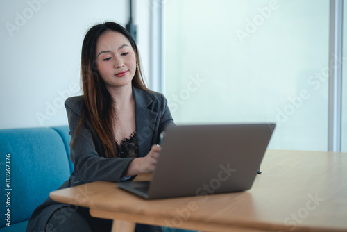 Asian female office worker or businesswoman is using a laptop to work in the office.