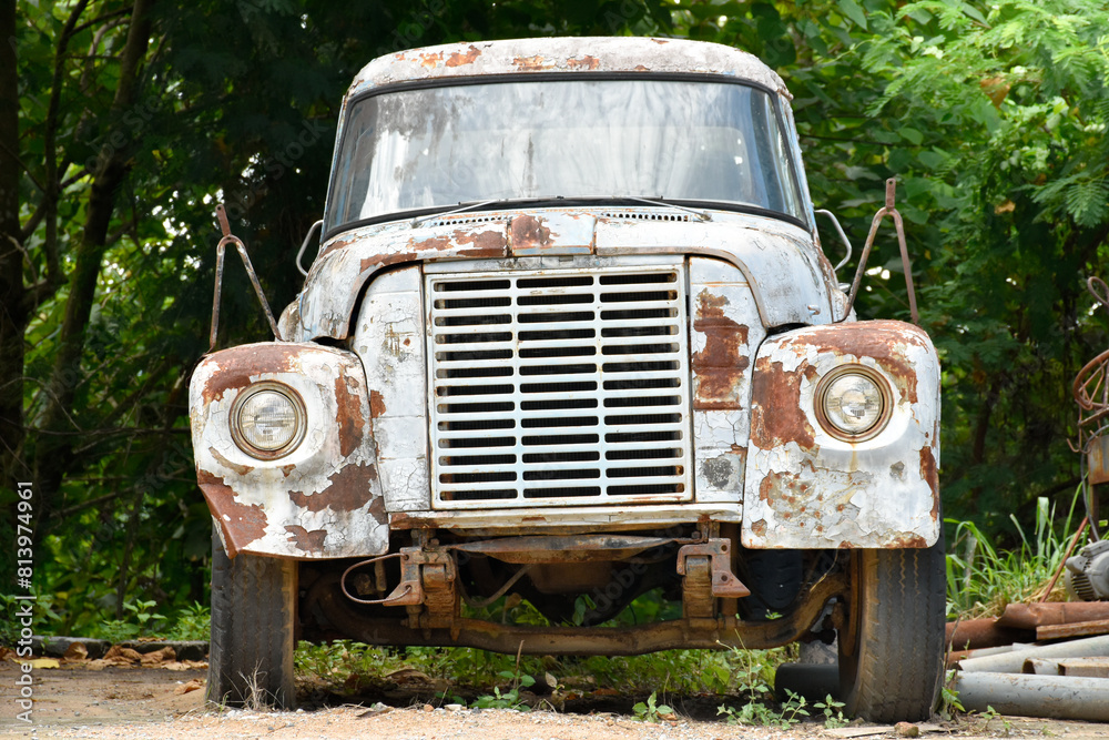 Abandoned classic truck and has rust font-view at old storage place in natural forest and scrap metal background for concept of cars and transportation. Abandoned classic truck and has rust font-view at old storage place in natural forest and scrap metal background for concept of cars and transportation.