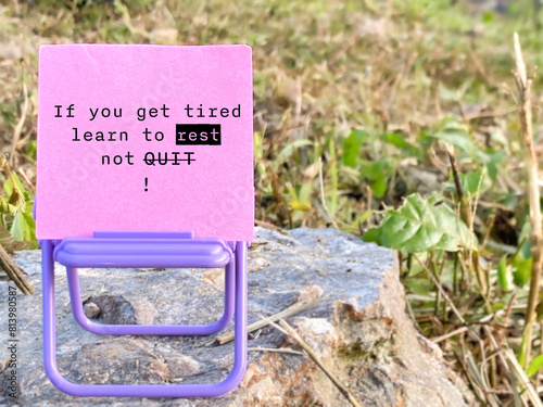 Inspirational motivational quote - IF YOU GET TIRED, LEARN TO REST, NOT QUIT. Note on paper with nature background. Stock photo
