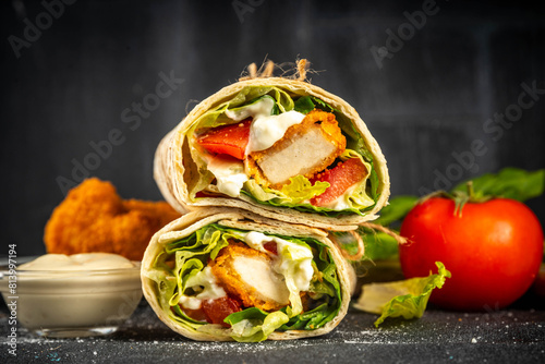 Fried chicken wraps with nuggets, fresh vegetables and buttermilk ranch sauce, healthy balanced street fast food, copy space