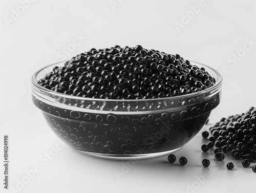 Black caviar in a glass bowl on a white table, top view.