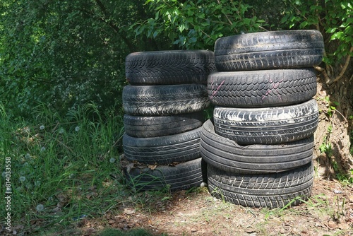 A pile of abandoned tires among the greenery.