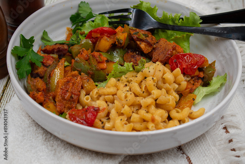 Vegan Pasta bowl consisting of roasted seitan with pepper, macaroni and hebs photo