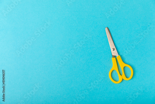 Bright children's scissors on a colored paper background. Stationery. Goods for school. Place for text. Copy space.Top view