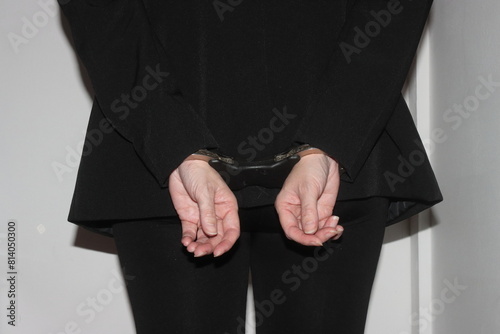 A closeup on a woman handcuffed behind her back after being arrested.