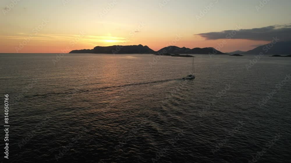 Yacht against the backdrop of the sunset sky is towing a rubber boat behind it. Shot taken from a drone. High quality 4k footage Yacht against the backdrop of the sunset sky is towing a rubber boat behind it. Shot taken from a drone. High quality 4k footage