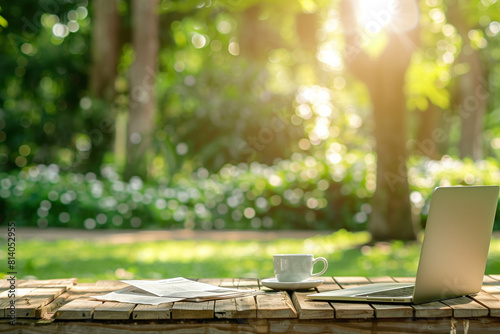 laptop mockup on wooden table in the garden with coffee cup and newspaper