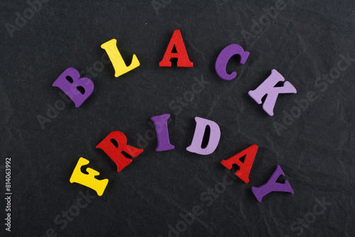 BLACK FRIDAY word on black board background composed from colorful abc alphabet block wooden letters, copy space for ad text. Learning english concept. photo