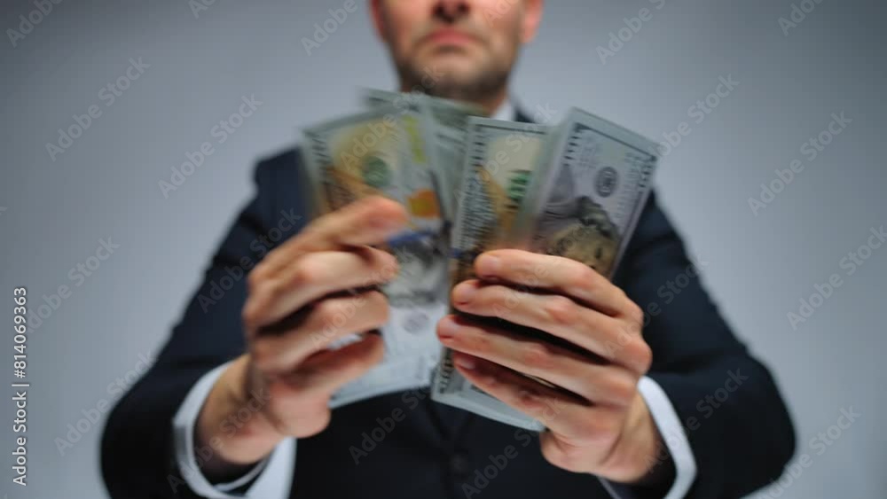 Formally dressed man counting US Dollar bills, close-up. Formally dressed man counting US Dollar bills, close-up.