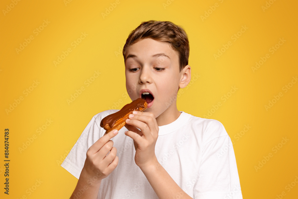 A delighted boy in a white t-shirt savors a bite of his tasty ice cream treat. A delighted boy in a white t-shirt savors a bite of his tasty ice cream treat.
