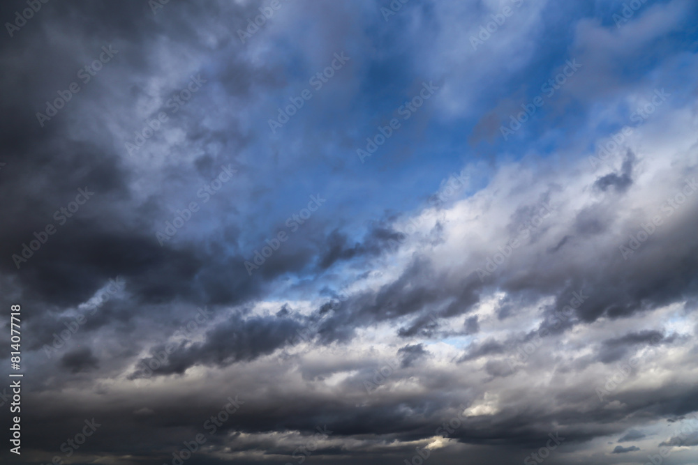 Storm cloudy epic dramatic sky with dark rain grey cumulus cloud and blue sky background texture, thunderstorm, heaven