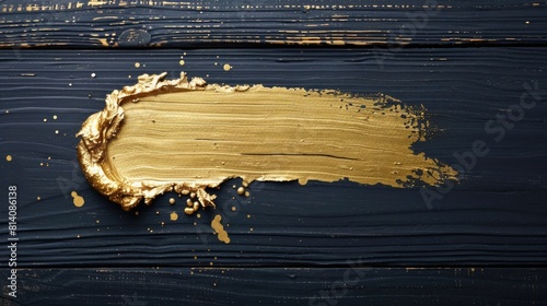 Gold paint strokes on a blue wooden surface creating an abstract design photo