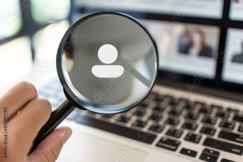 Person holding a magnifying glass over a laptop with a job listing icon floating on a white background,