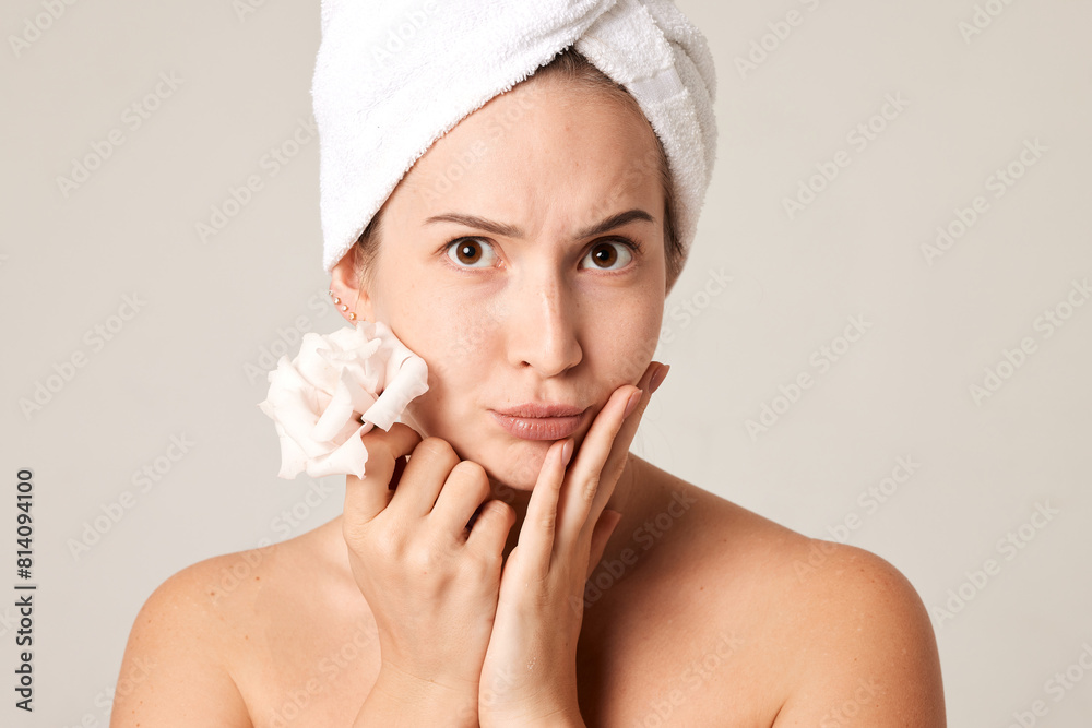 portrait of a beautiful girl with a towel on her head holding a flower