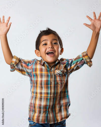 A young boy with his hands up in the air.