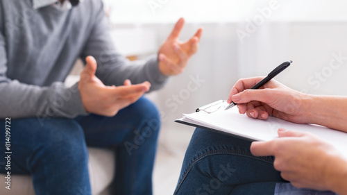 Foto A person is seated in a neutral-colored office space, engaging in a discussion w