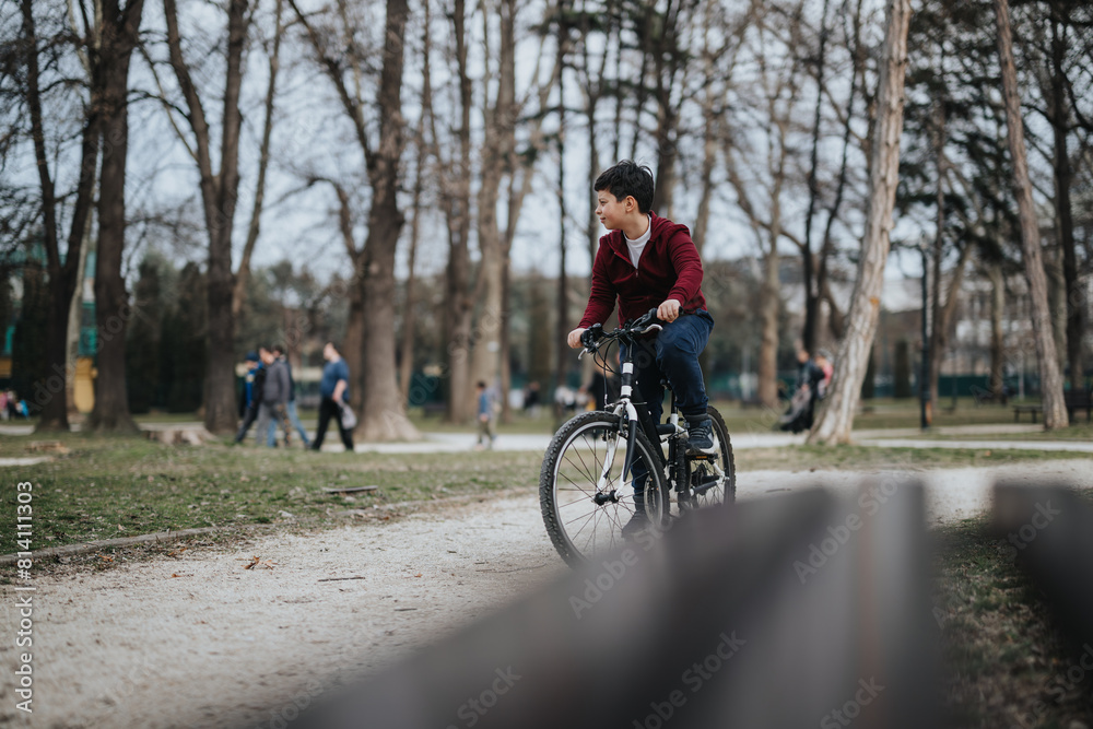 A young boy riding his bike in an urban park, surrounded by lush greenery and enjoying nature.