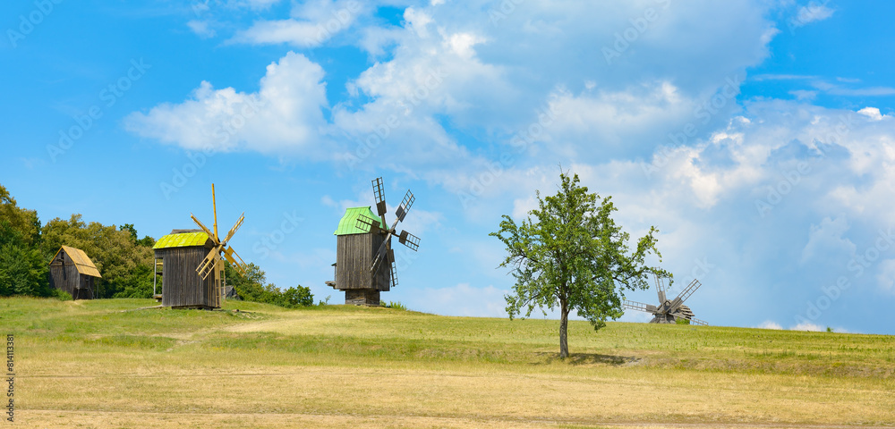 Fototapeta premium Old wooden mills against background blue sky.