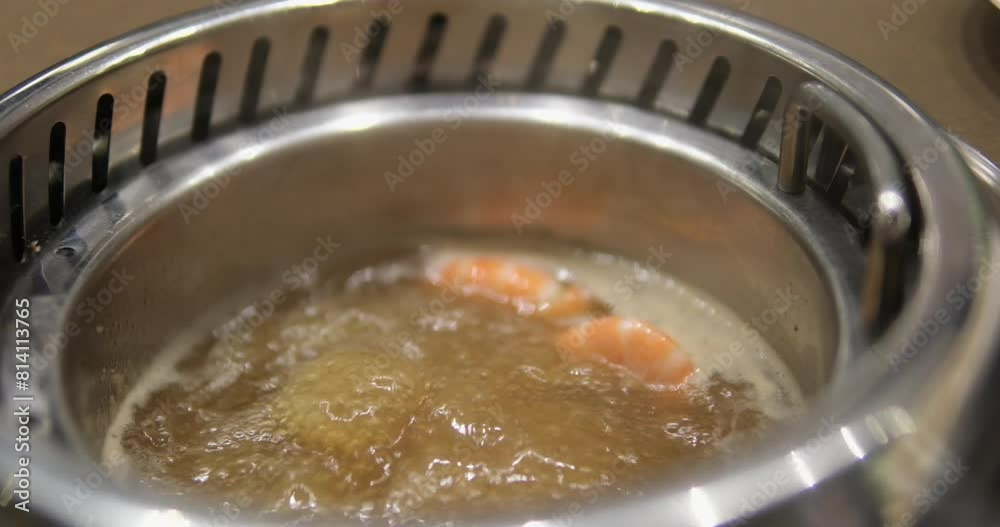 Asia buffet Young woman in an asian cafe cook food in a hot pot. Food is served on a conveyor on a little plates. Food conveyor. Asia buffet Young woman in an asian cafe cook food in a hot pot. Food is served on a conveyor on a little plates. Food conveyor.