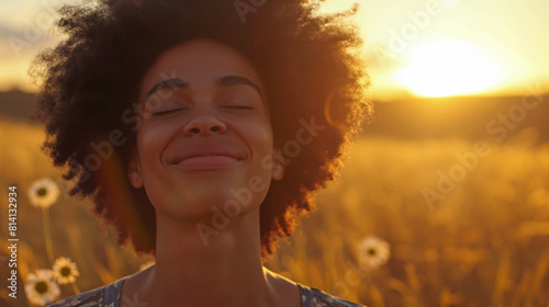 Backlit Portrait of calm happy smiling free black woman with closed eyes enjoys a beautiful moment life on the fields at sunset	
