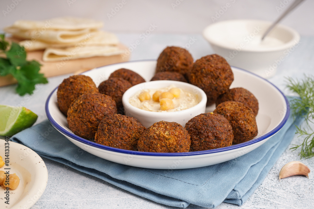 Plate with delicious falafel balls and hummus on light background Plate with delicious falafel balls and hummus on light background