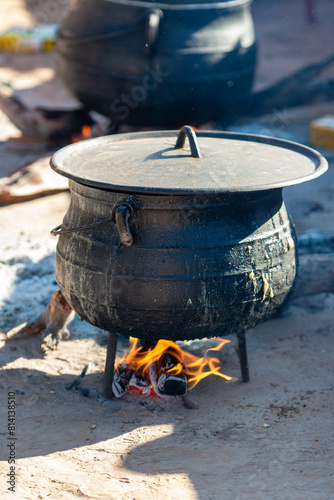 Φωτογραφία three legged african black cast iron pot cauldron, cooking outdoors, slow cookin
