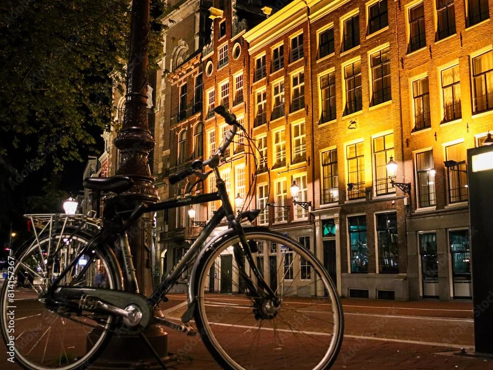 Fototapeta premium Amsterdam, Netherlands bike and architecture at nighttime