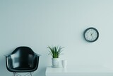 Minimalistic home office space with modern chair, plant, and wall clock