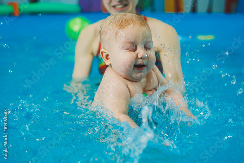 Swimming pool for babies. A baby learns to swim with a coach