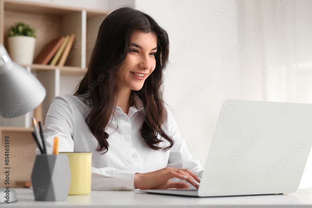 Beautiful young happy businesswoman working with laptop at office Beautiful young happy businesswoman working with laptop at office